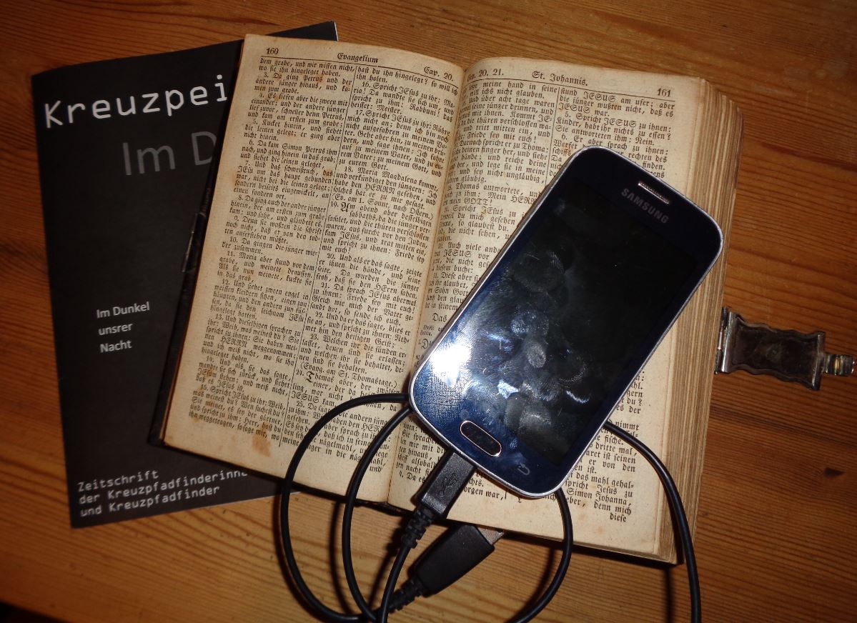 offene Bibel mit Handy